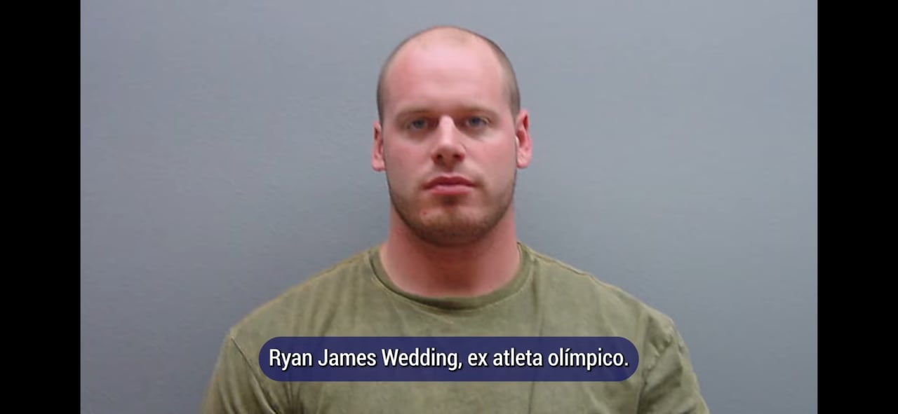 A man in a green t-shirt looks at the camera.