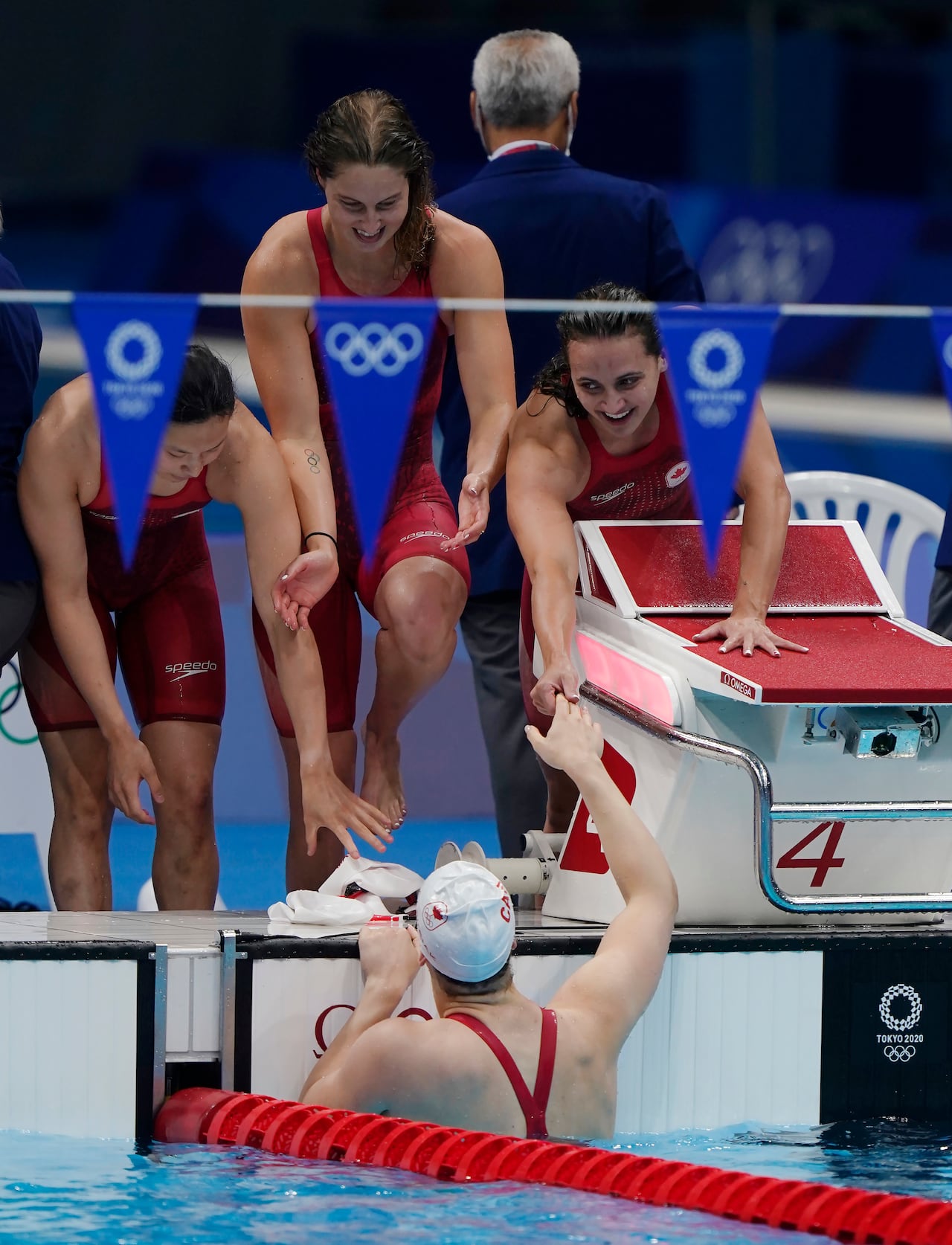 Four swimmers celebrate at the end of a race.