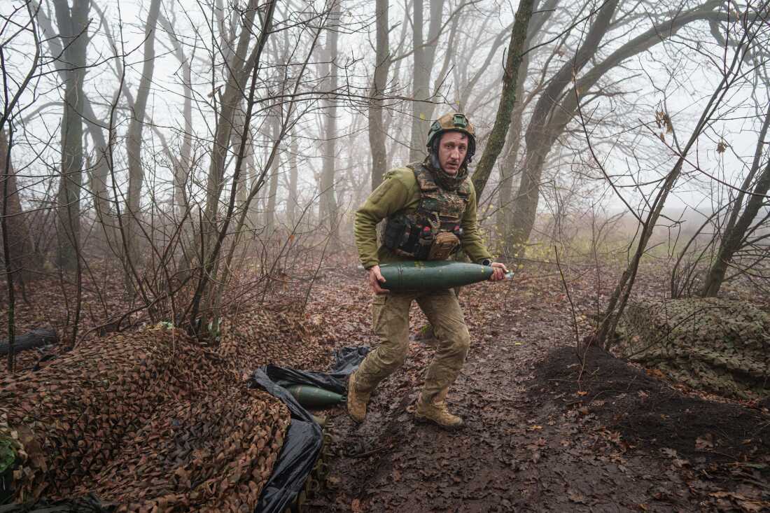 A Ukrainian serviceman of the Da Vinci Wolves Battalion carries an artillery shell before firing toward Russian positions at the front line in eastern Ukraine, on Nov. 28.