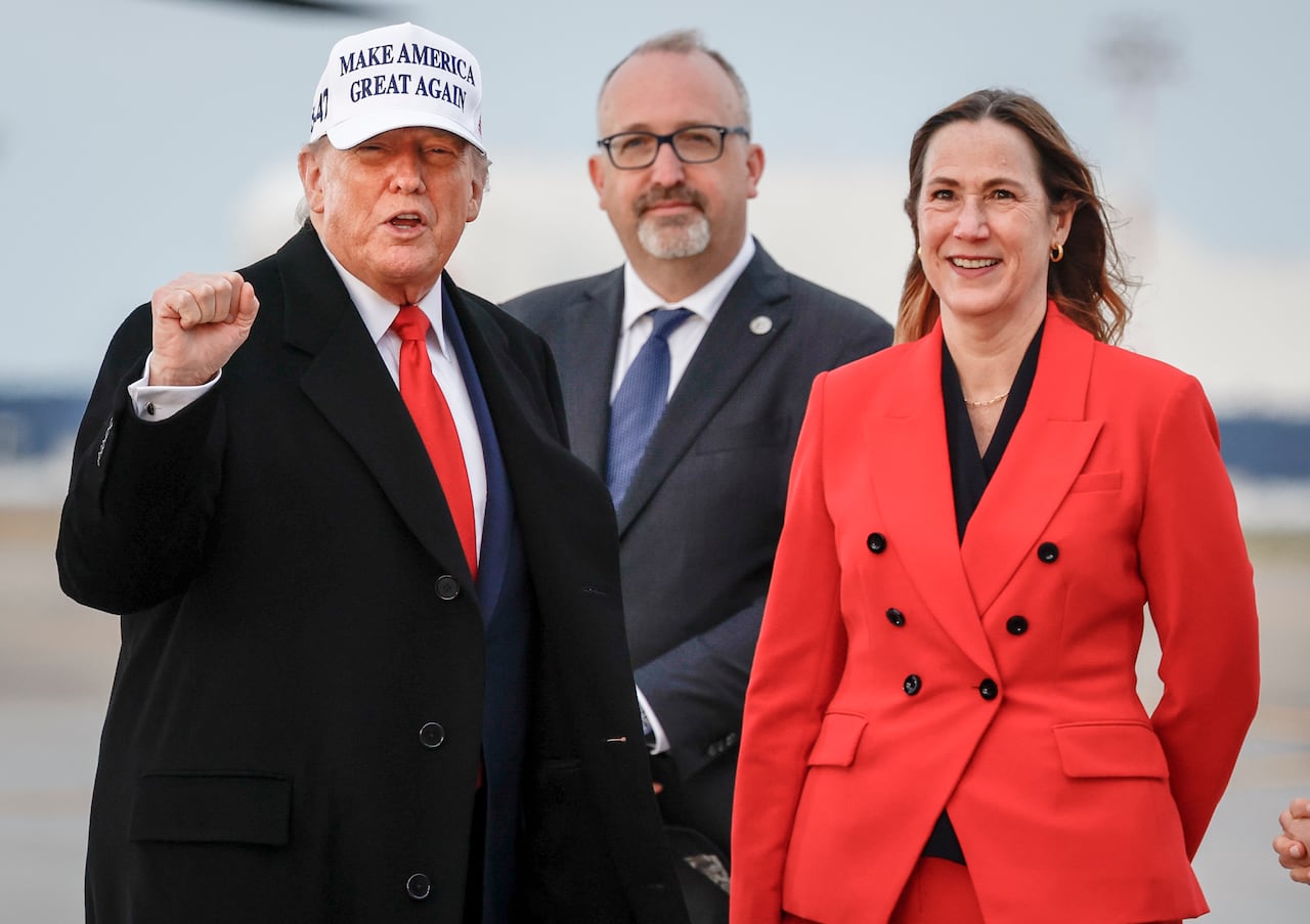 U.S. President Donald Trump, left, pumps his fist as he is greeted by Kirsten Hillman, Canadian Ambassador to the United States, right, as he arrives in Calgary, Alta., Sunday, June 15, 2025, to attend the G7 Leaders meeting taking place in Kananaski