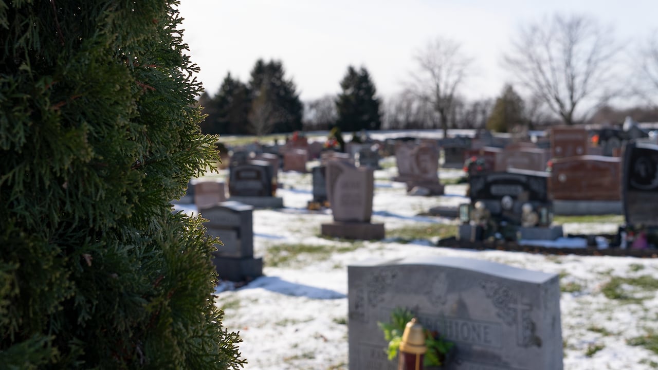 A photo of a gravestones on a snowy day