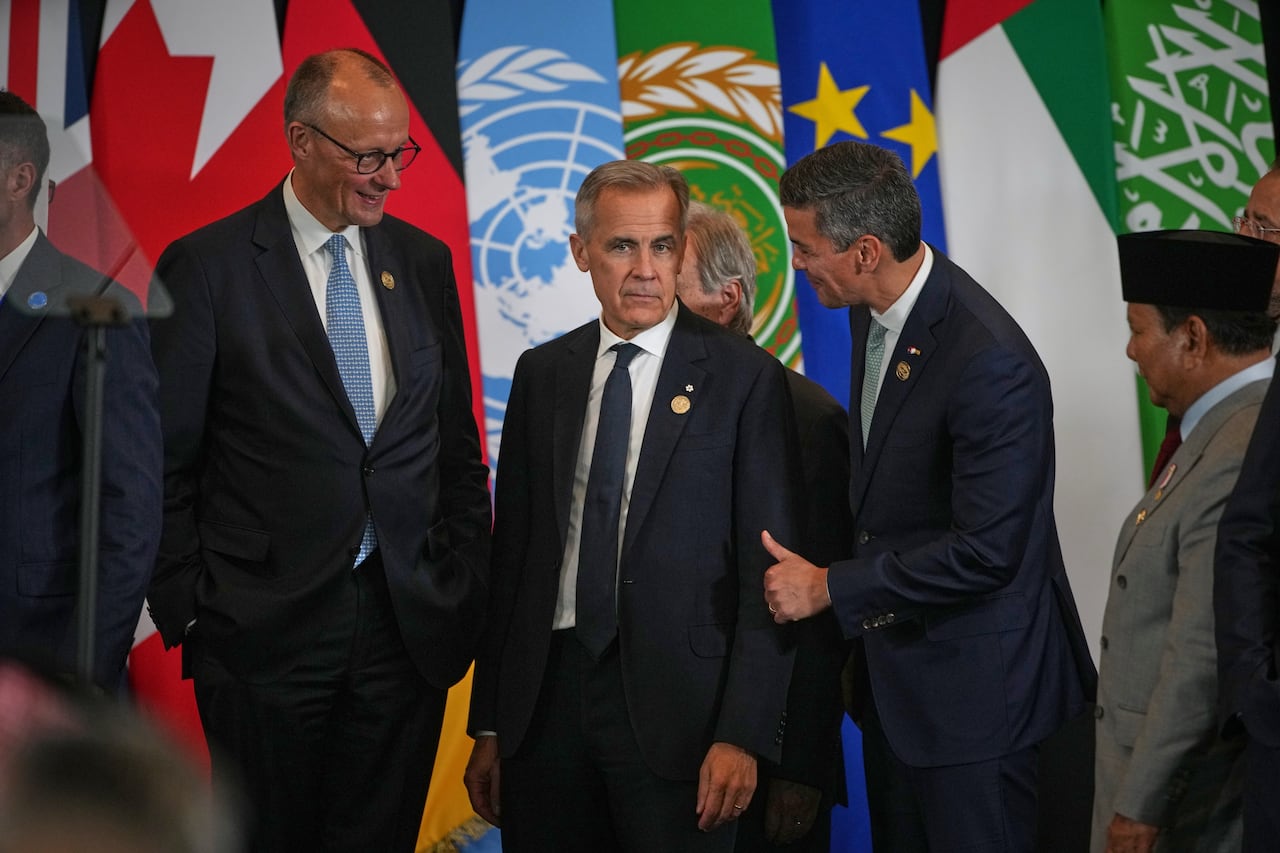 Spanish Prime Minster Pedro Sanchez, right, talks with Canadian Prime Minister Mark Carney, centre, and German Chancellor Friedrich Merz during the Gaza peace summit.