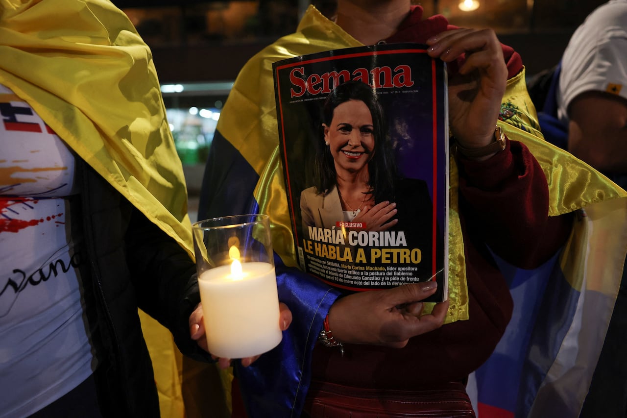 Person holding a magazine with woman's face on the cover with a candle beside it