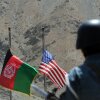 Afghan and US flags are raised as a policeman keeps watch during a ceremony to hand over security control in the rugged mountains of the Panjshir valley on July 24, 2011.