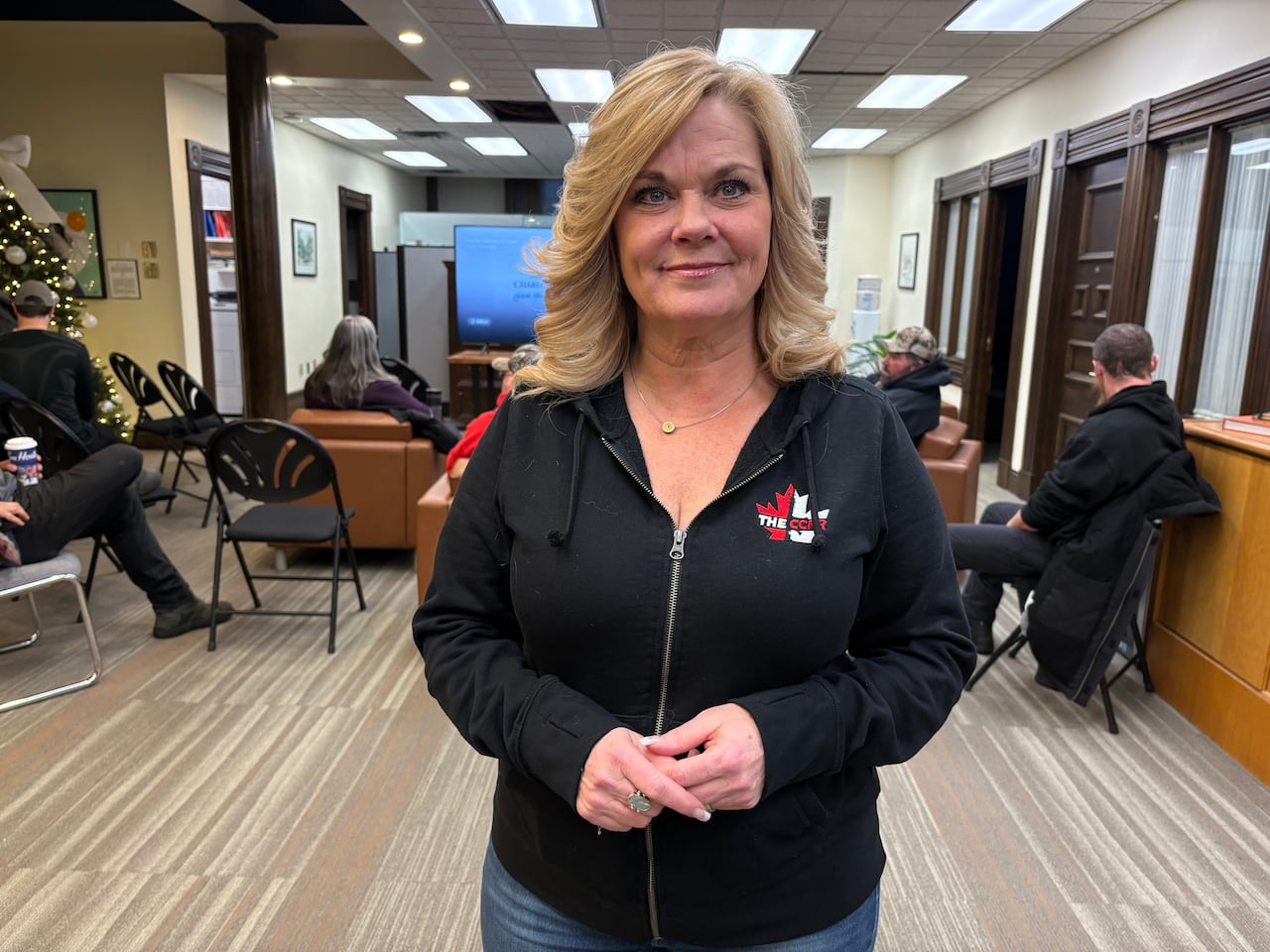 A woman in a back hoody stands in the lobby of Charlottetown City Hall.