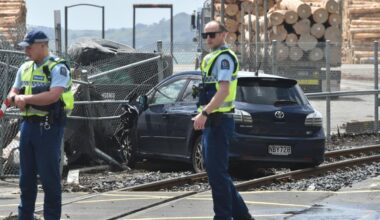 Car ends up on train tracks after crashing through fence