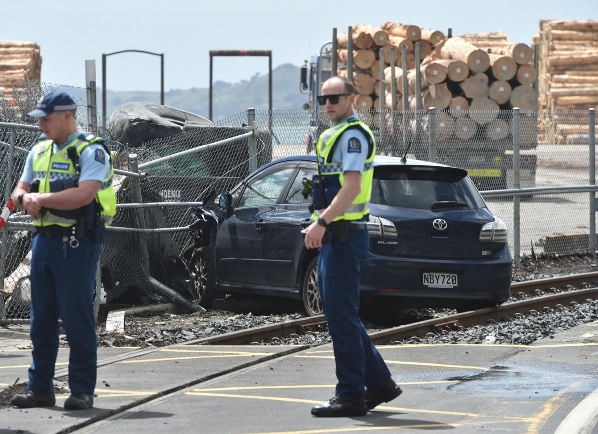 Car ends up on train tracks after crashing through fence