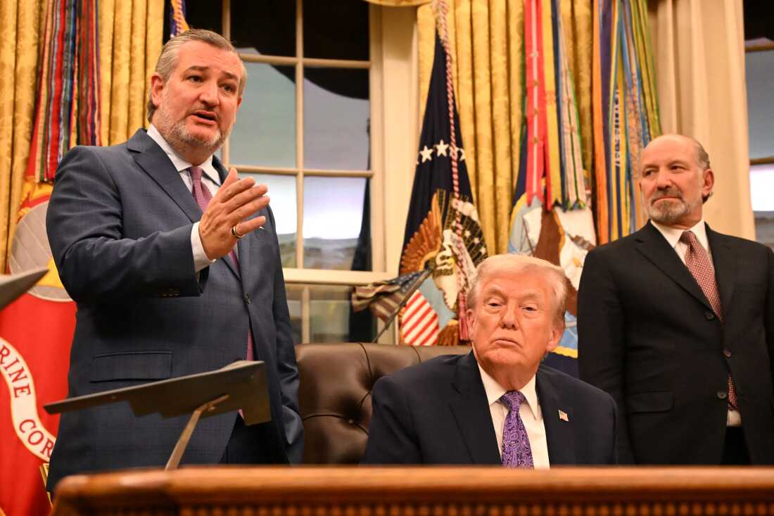 President Trump, center, and Secretary of Commerce Howard Lutnick, right, listen as U.S. Sen Ted Cruz, R-Tex. speaks during a signing ceremony for an executive order on AI at the White House on Dec. 11, 2025.