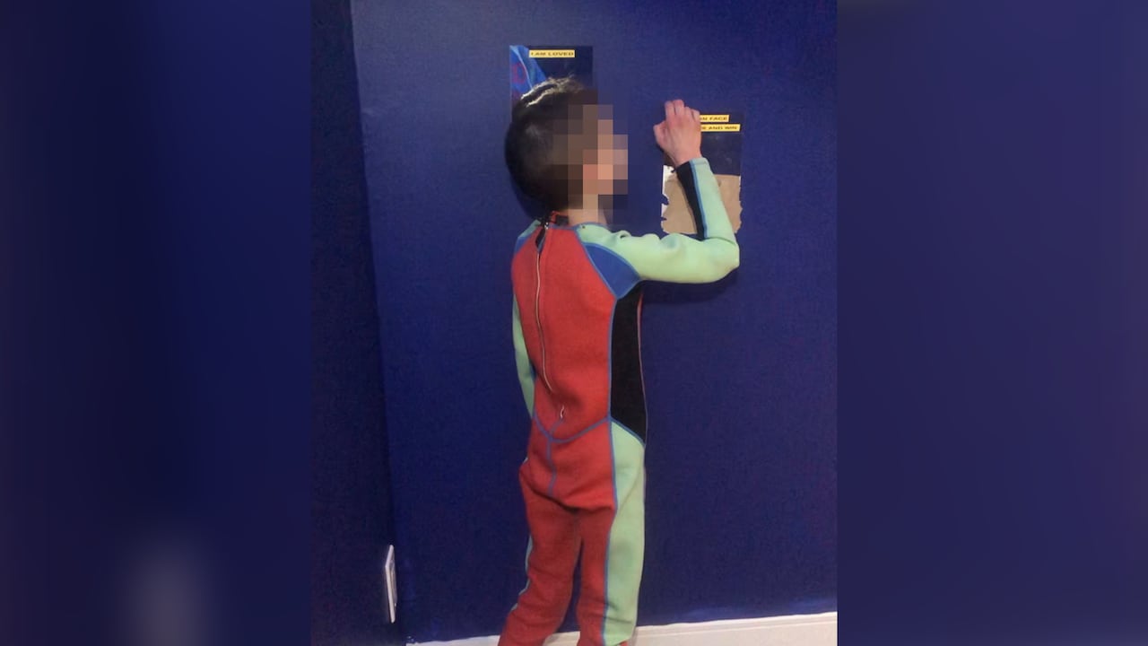 boy stands at wall 