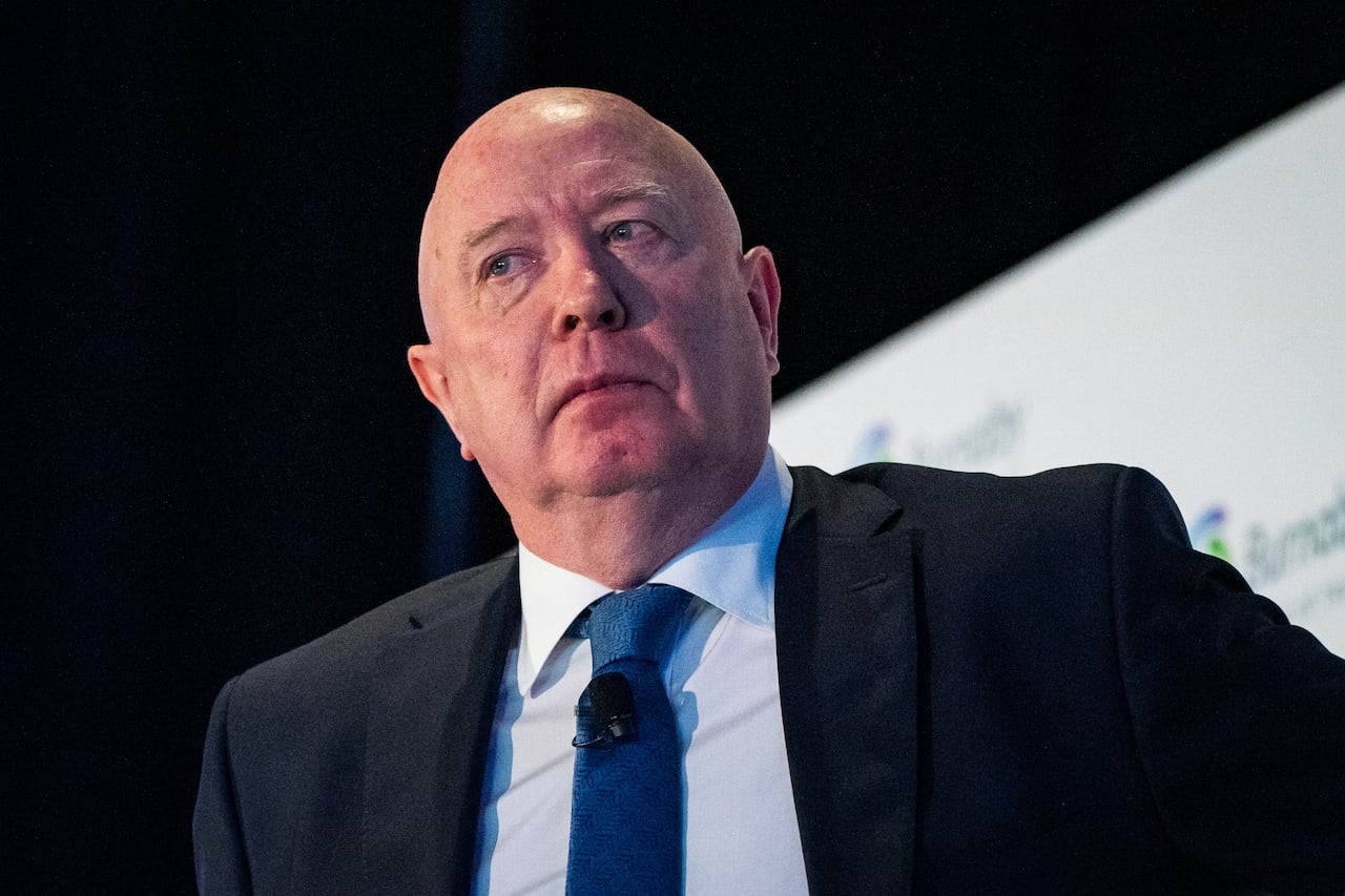 A man stands in front of a screen