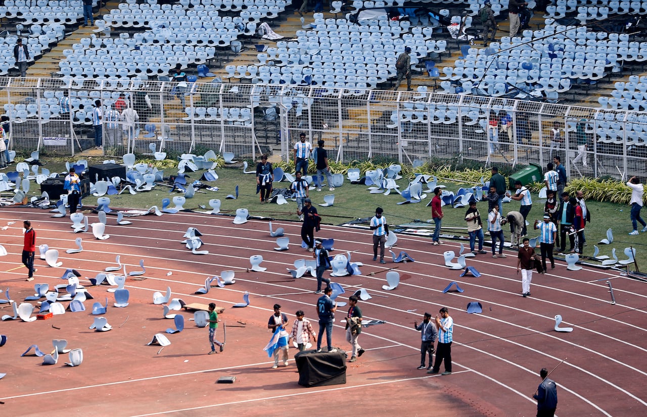 Wide shot of soccer pitch with ripped off seat strewn across it. 