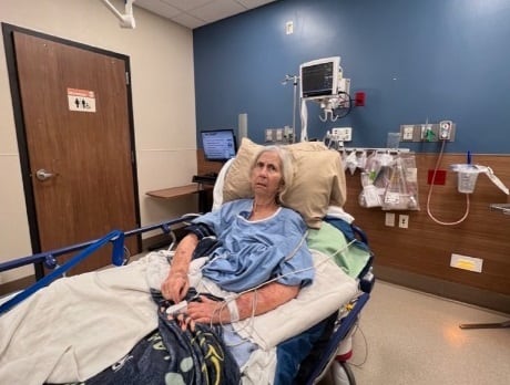 Elderly woman in distress in hospital bed. 