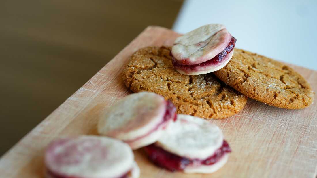 Kiss cakes are displayed on top of ginger cookies that are dusted with sugar.