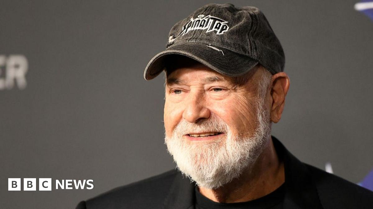 Hollywood actor and director Rob Reiner wearing a black cap and black jacket.