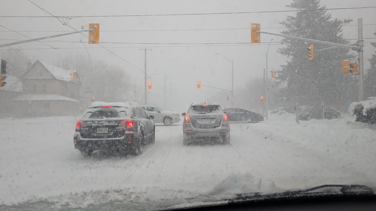 Heavy snow falls at the intersection of Cheapside and Richmond streets in London, Ont. around noon on Dec. 14, 2025.