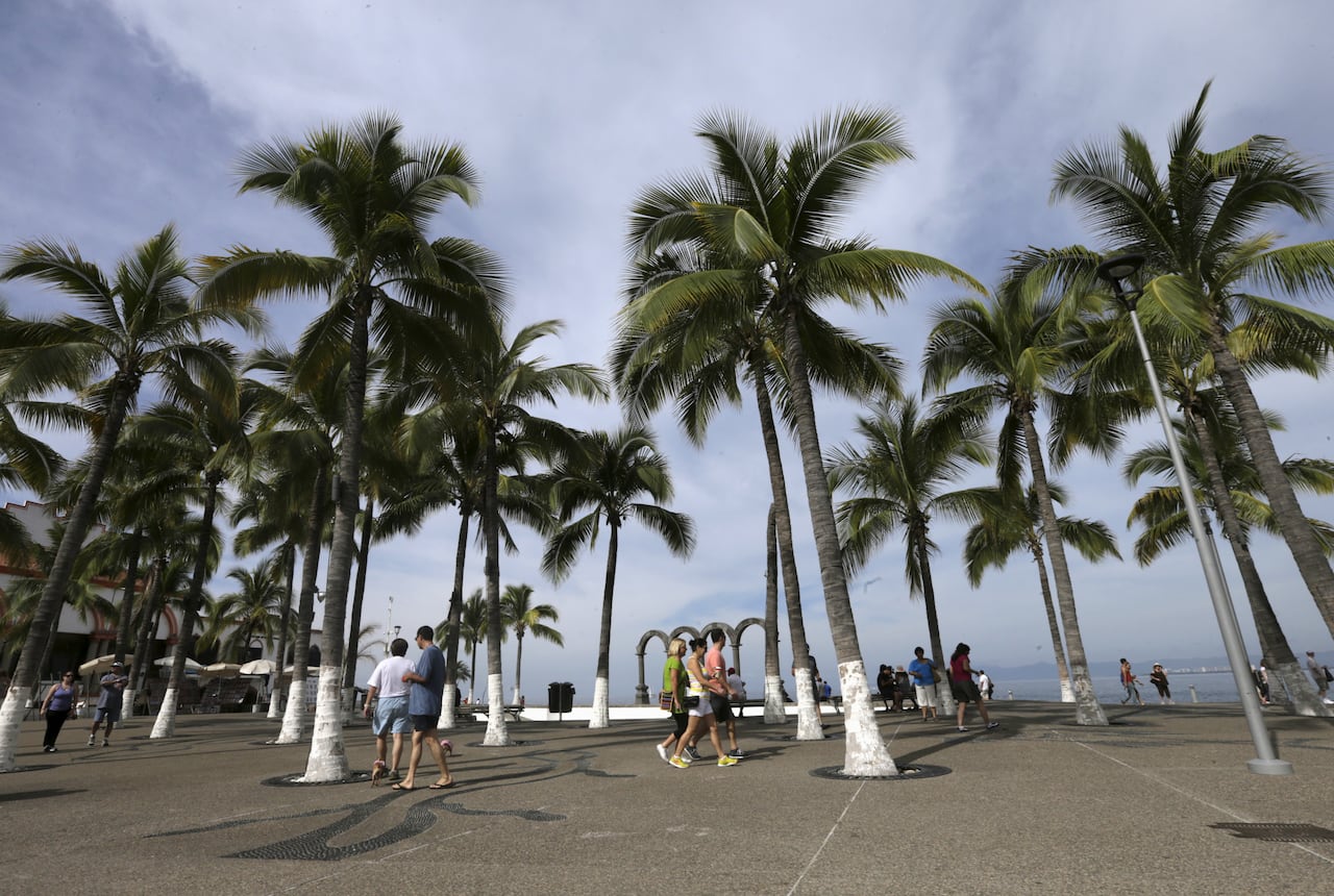 Tourists walk along the city's historic boardwalk in the Pacific beach resort of Puerto Vallarta, Mexico December 30, 2015