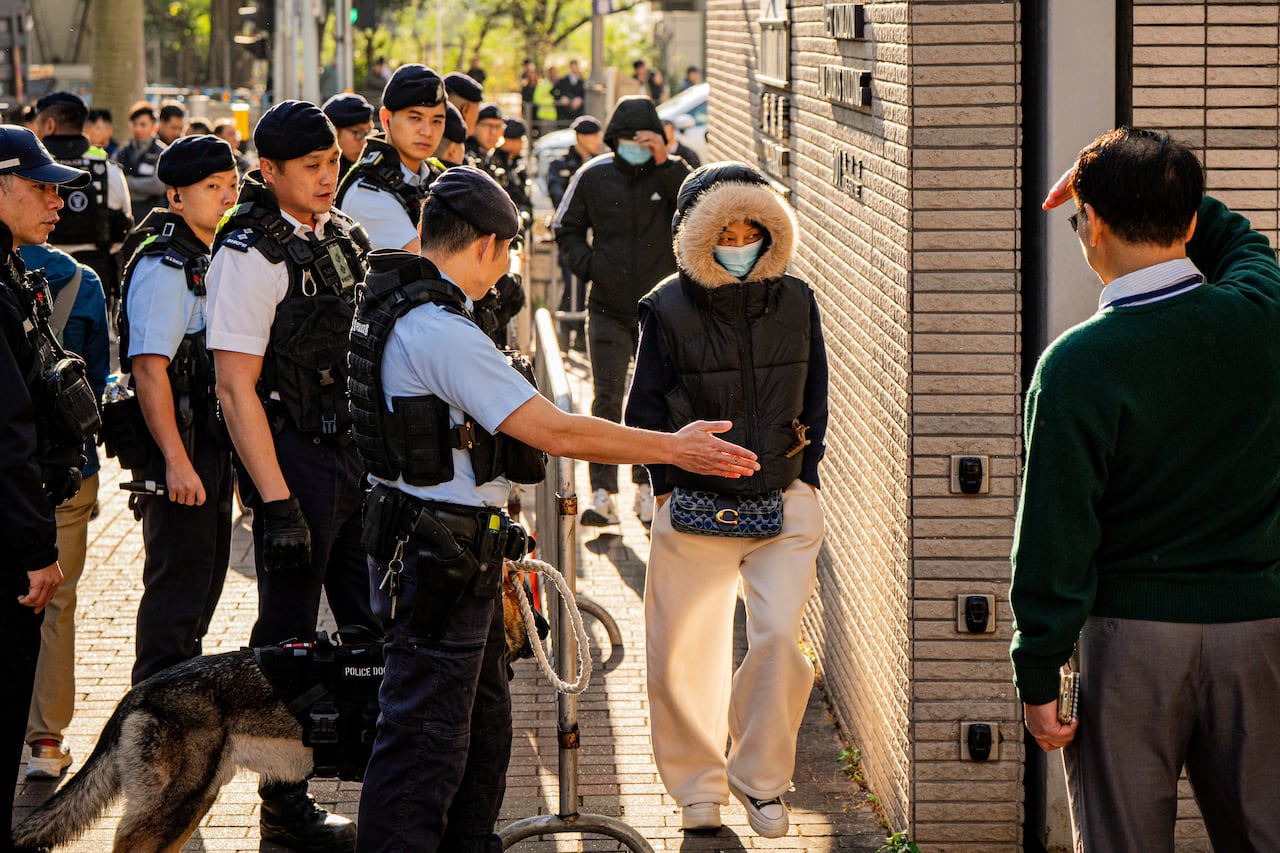 Police officers direct people into a building.