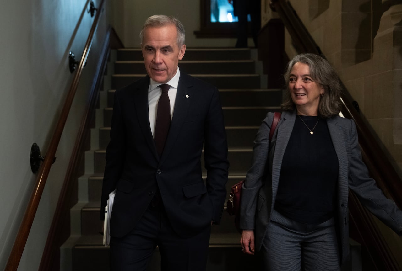 A man and a woman walk down the stairs 