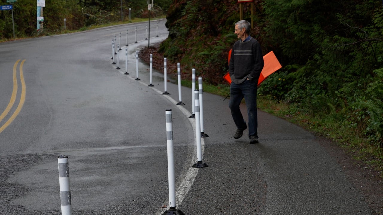 Steven Earle walks among white reflective delineators on Gabriola Island. 