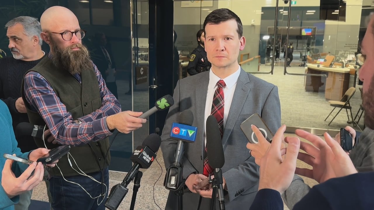 Calgary Mayor Jeromy Farkas stands in front of scrum of reporters