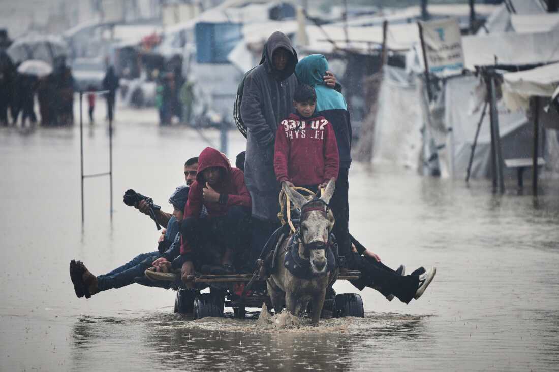 Palestinians cross a flooded street following heavy rain in Khan Younis, southern Gaza Strip, Dec. 11.