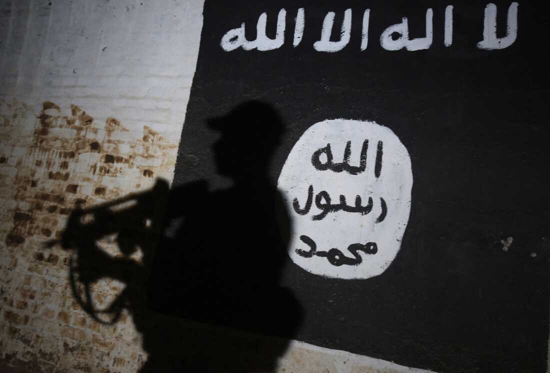 A member of the Iraqi forces walks past a mural bearing the logo of the Islamic State group in a tunnel that was reportedly used as a training center by the jihadists, on March 1, 2017, in the village of Albu Sayf, on the southern outskirts of Mosul.