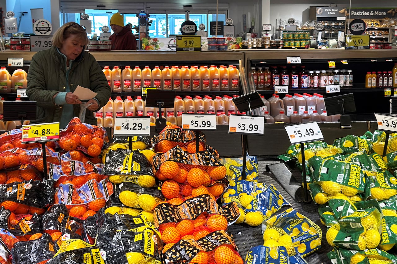 A person shops for groceries in the produce section of a store.