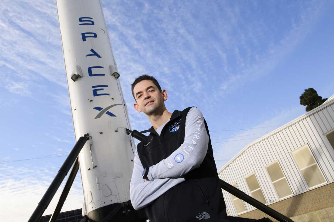 Jared Isaacman poses next to part of a rocket at the California headquarters of SpaceX in 2021.