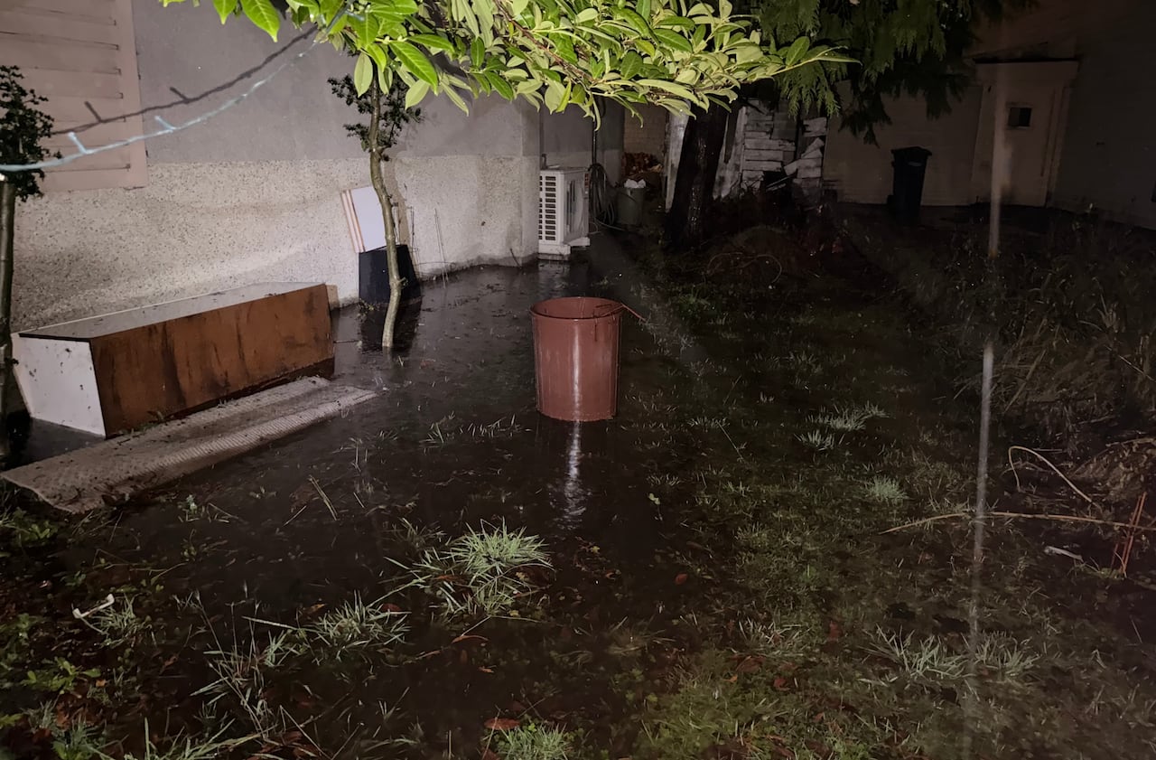 A flooded backyard is pictured in the nighttime. 