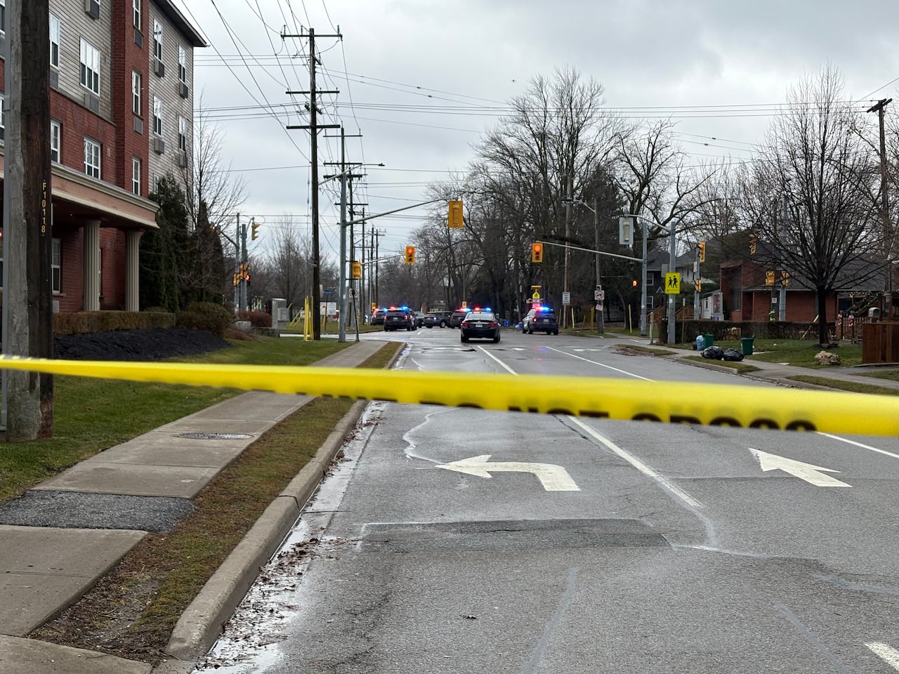 caution tape, police cars on residential street