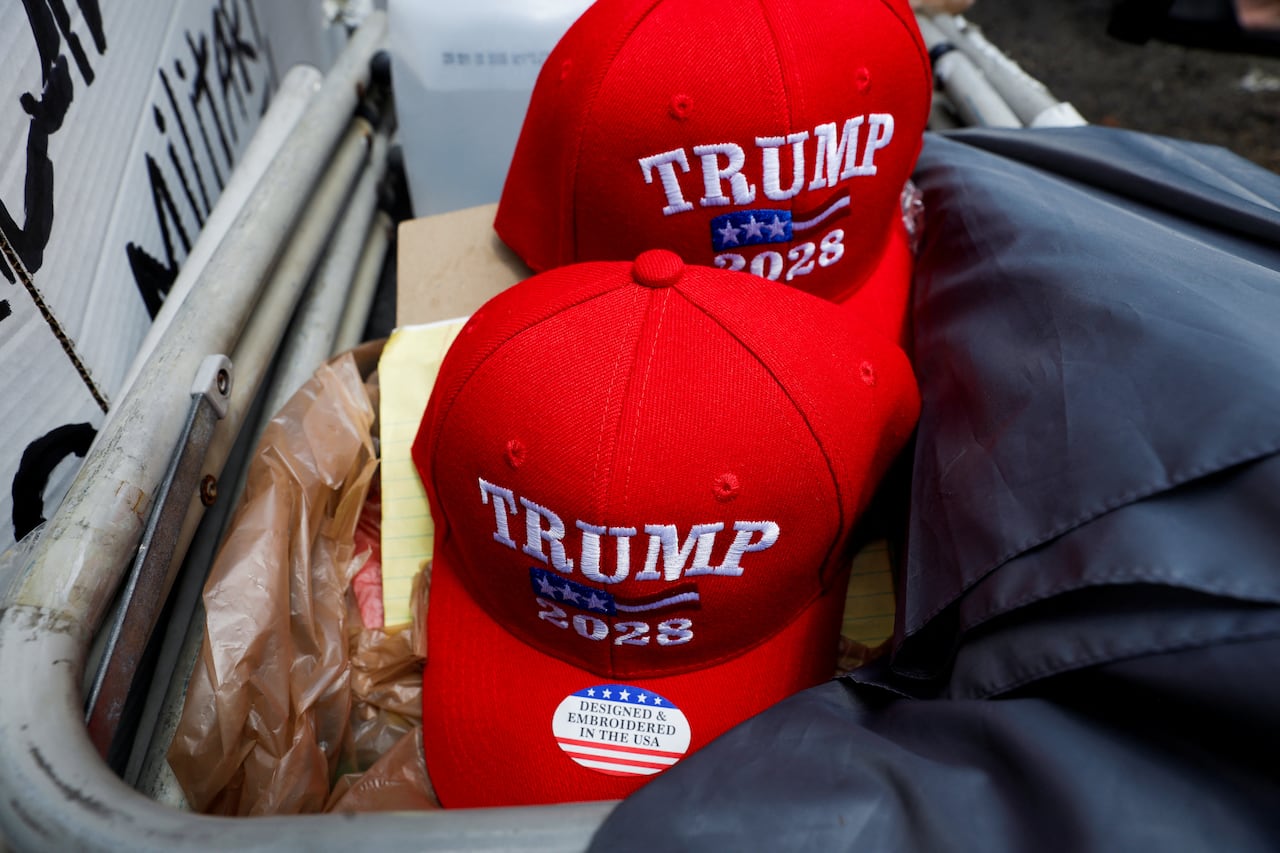 Red baseball hats that say Trump 2028 are shown.