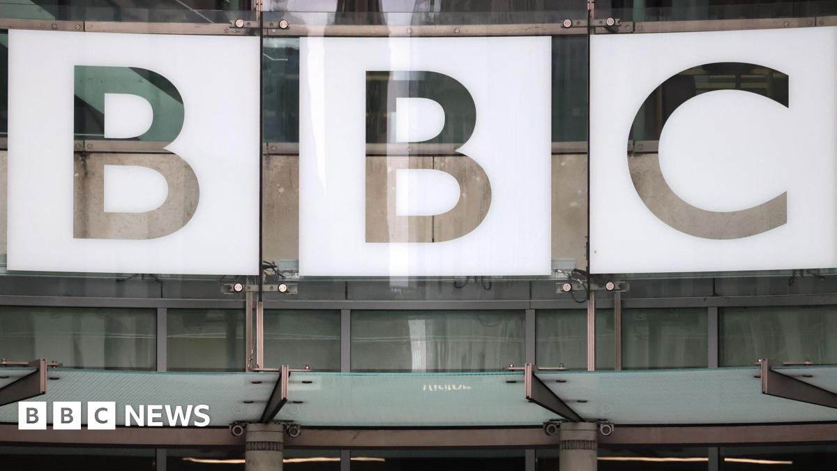 BBC chair Samir Shah walking down a street carrying a file