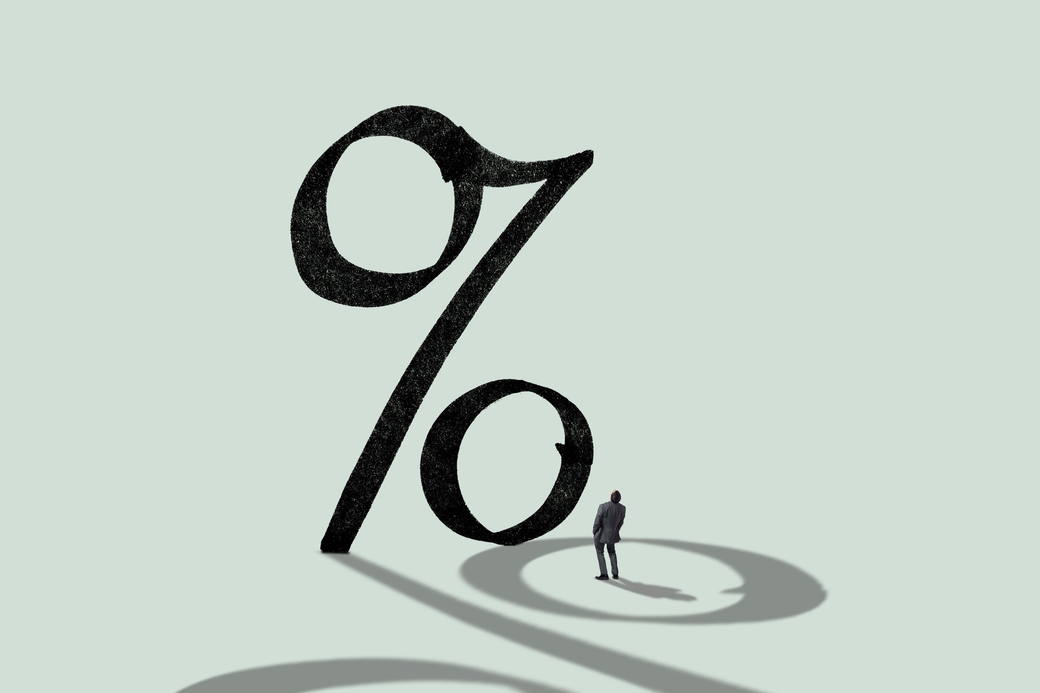 A person looking up at a large percent sign.