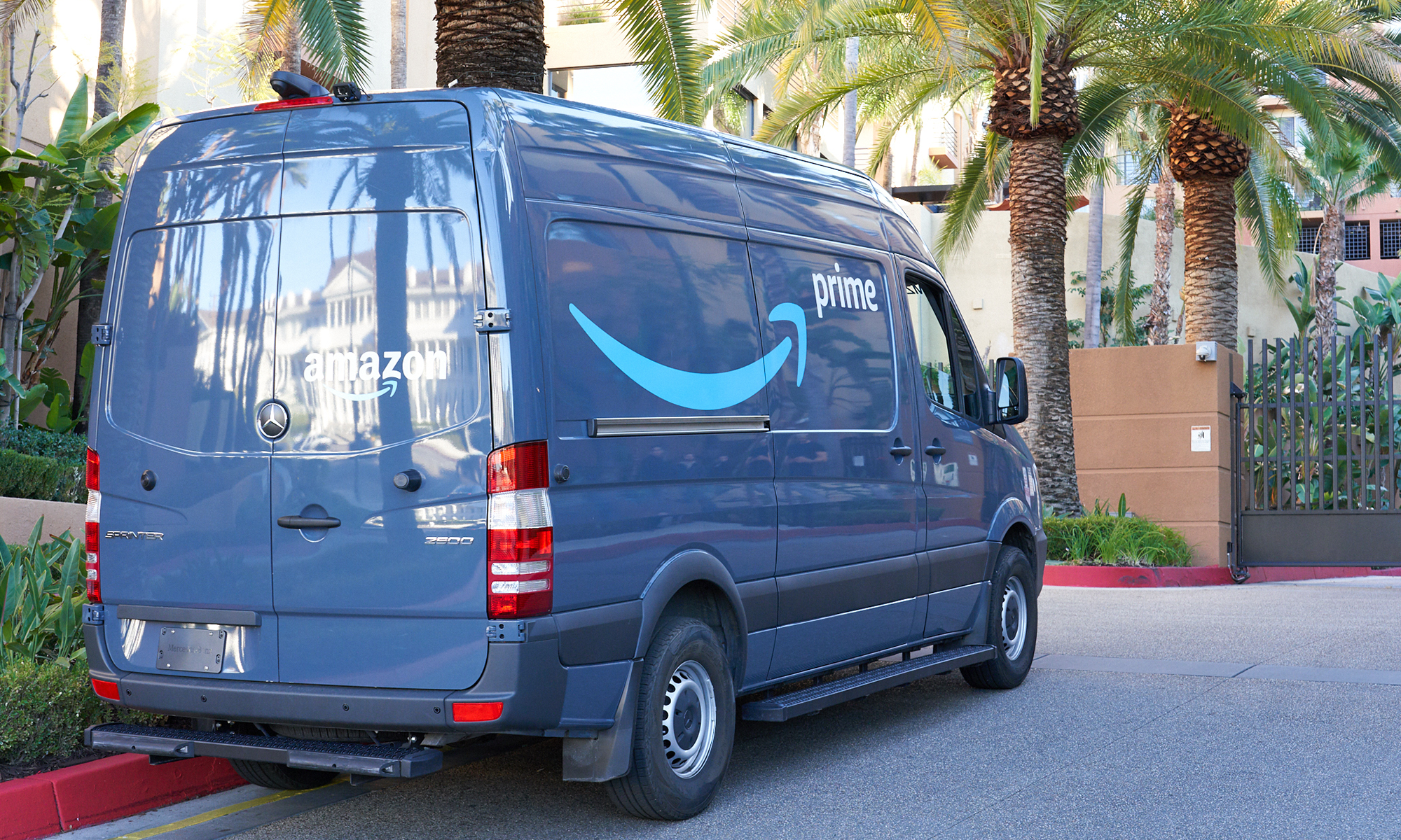 A blue Amazon van on the street. 