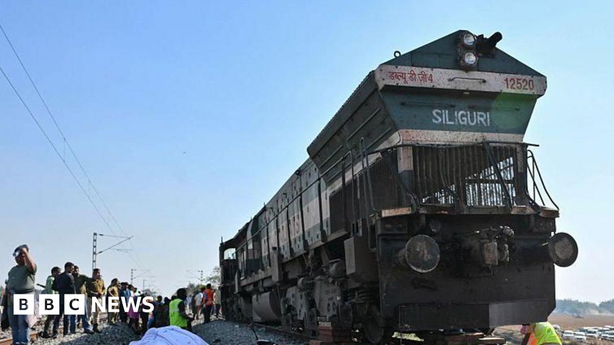 A covered elephant body lies along railway tracks  in the Hojai district, Assam state, as police and railway officials examine the scene. Photo: 20 December 2025