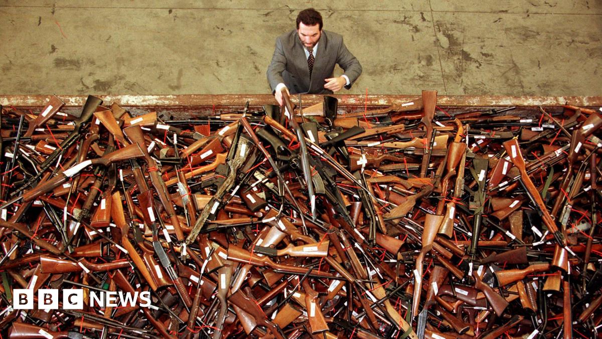In a photo dated July 28, 1997, Mick Roelandts, firearms reform project manager for the New South Wales Police, looks at a pile of about 4,500 prohibited firearms in Sydney that have been handed in that month under the Australian government's buyback scheme.