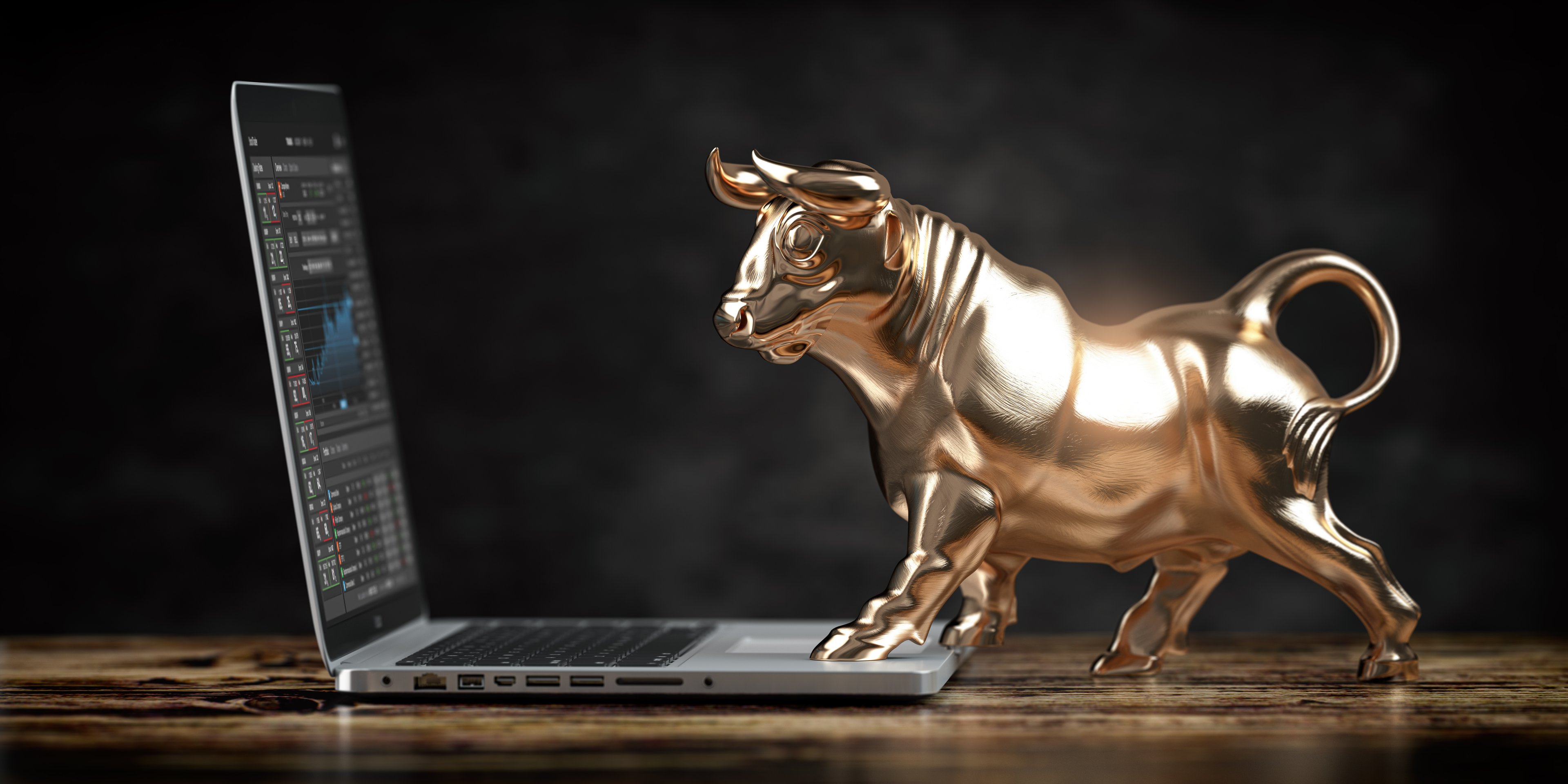 Bull statue trading stock on a laptop.