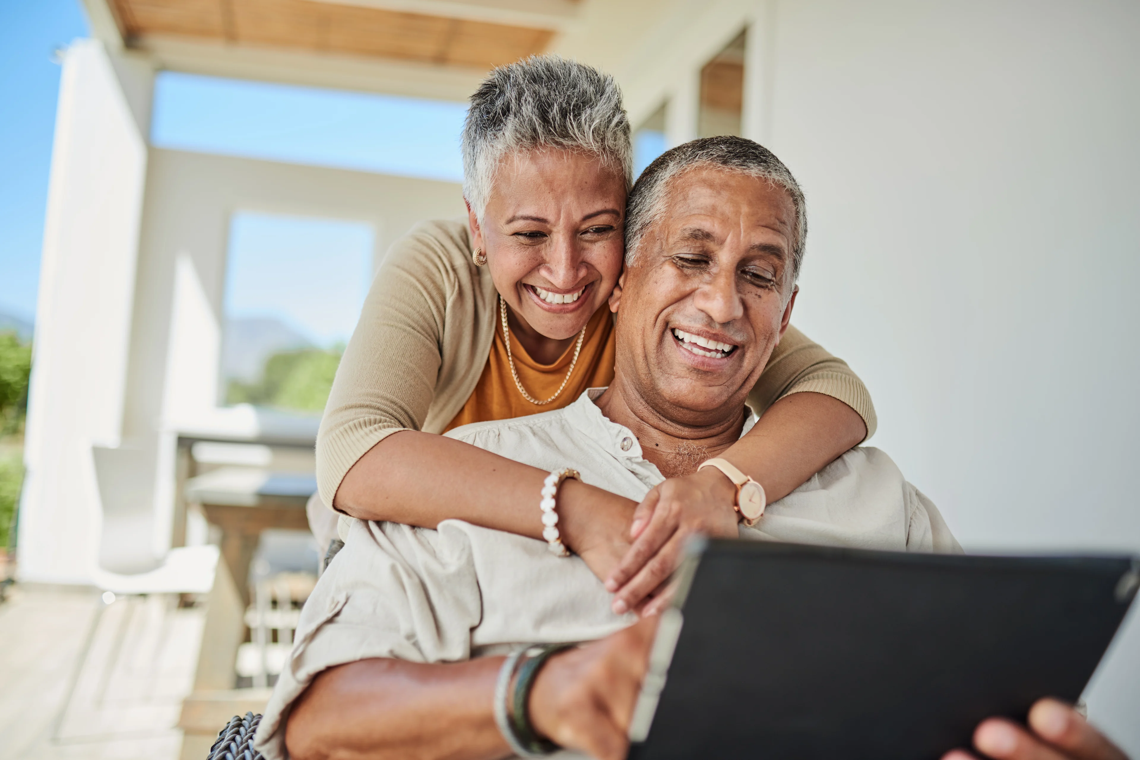 A couple looking over a tablet.