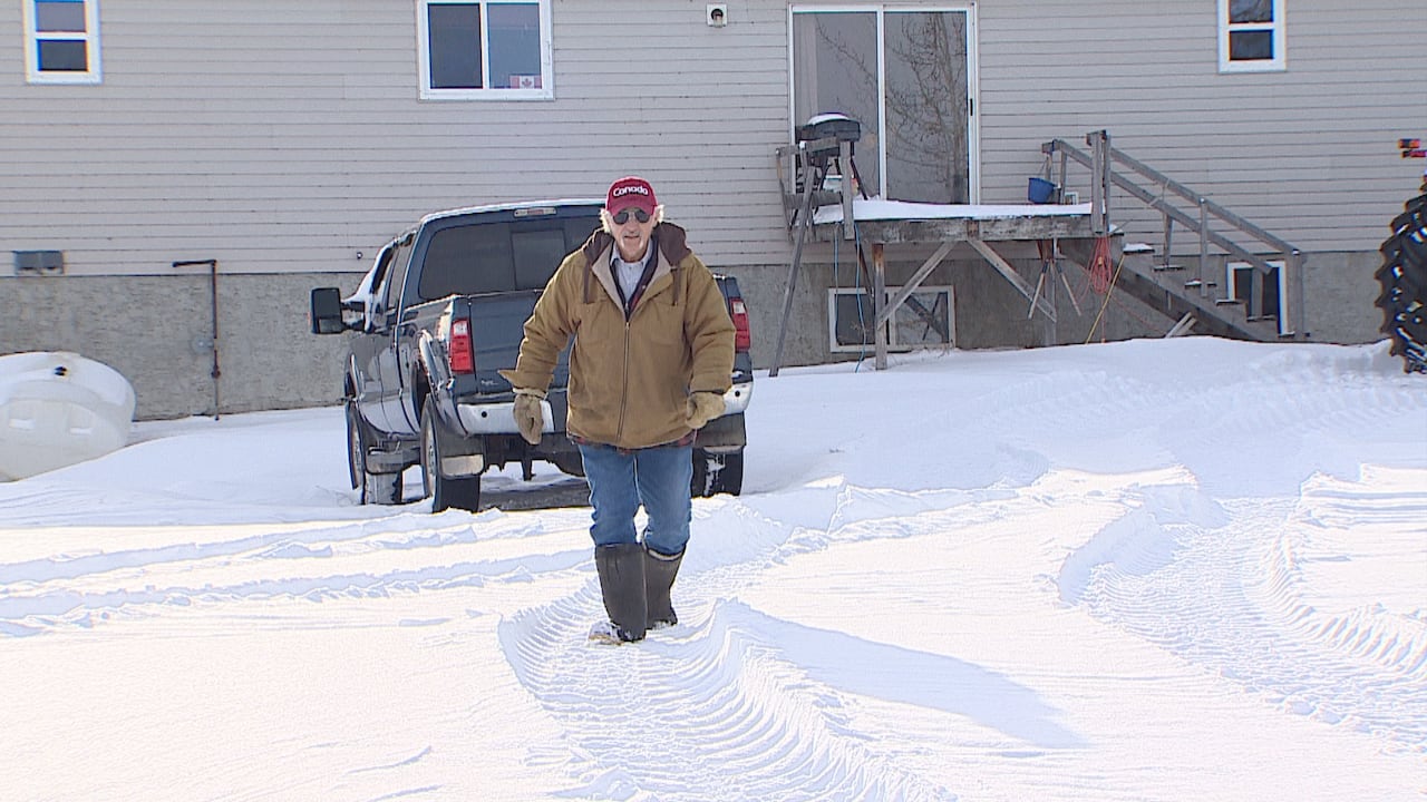 A man walks through a snowy field.
