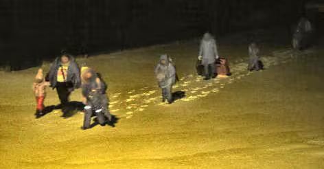 A group of people walking through deep snow.