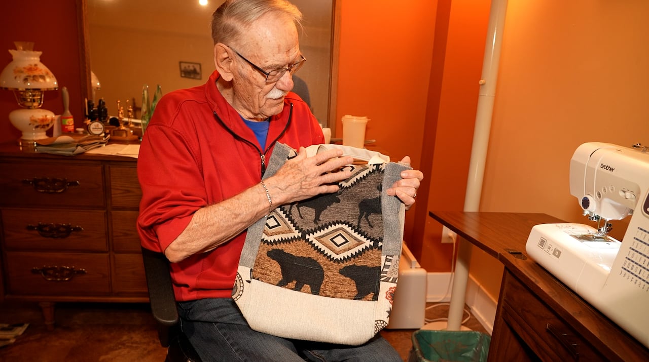 Man in red shirt holds bag
