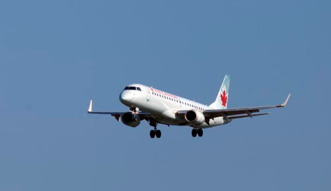 An Air Canada plane is seen against a clear blue sky