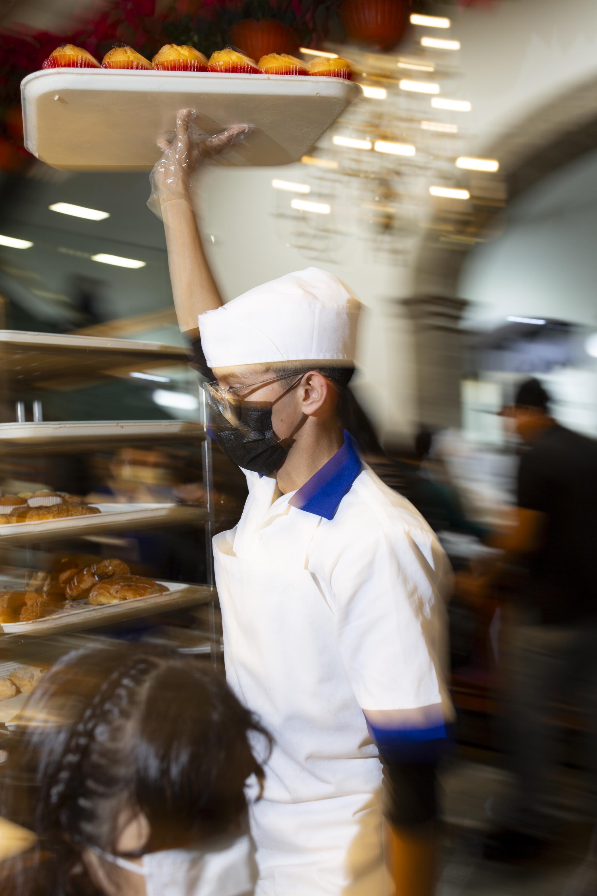 A worker restocks bread supplies at the Ideal bakery.