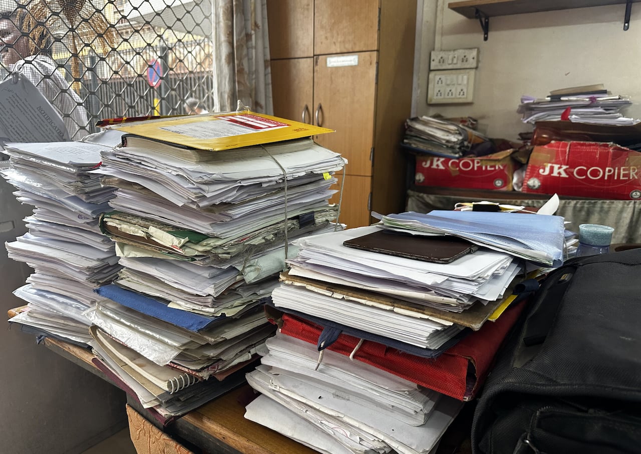 Piles of papers sit on a desk.