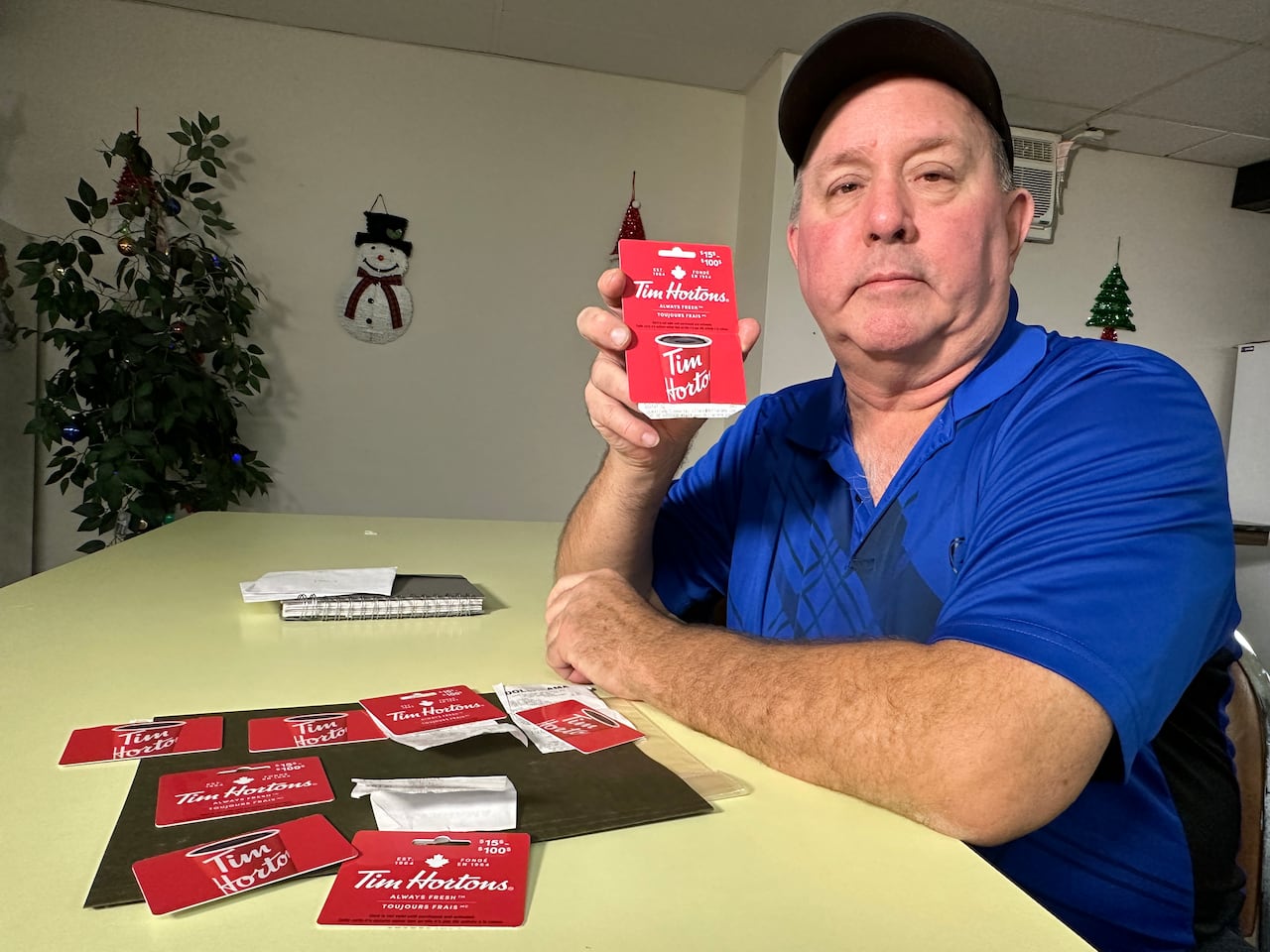 A senior-age man with Tim Hortons gift cards.