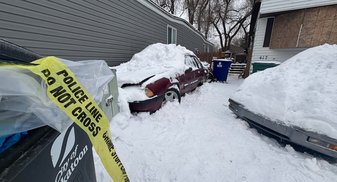 yellow caution tape is in a garbage bin, and a window is boarded over