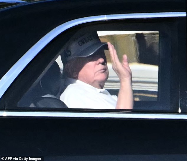 US President Donald Trump waves from his motorcade as he returns to his Mar-a-Lago club from Trump International Golf Course in Palm Beach, Florida, on December 22, 2025. (Photo by ANDREW CABALLERO-REYNOLDS / AFP via Getty Images)