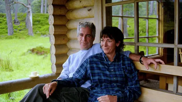 US justice department release one foto wey show Jeffrey Epstein and im co-conspirator Ghislaine Maxwell as dem siddon close togeda outside one wooden home, wey be like cabin for a wooded area. 
