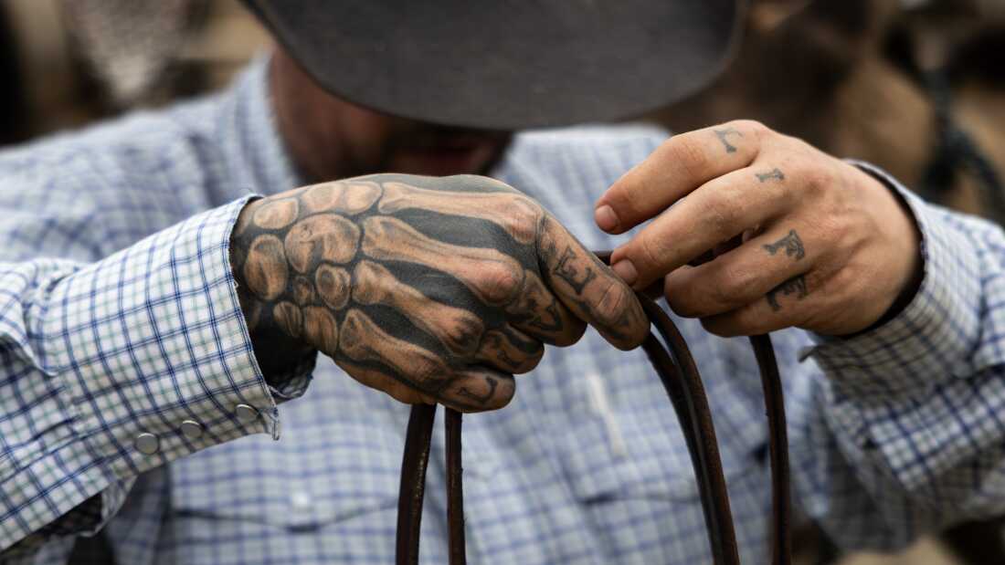 Mason "Bric" LaDue, a hip-hop music industry professional turned cattle rancher, takes the reins off of his horse, Valero, on Feb. 5, 2025, at his family's ranch in Marquez, Texas.