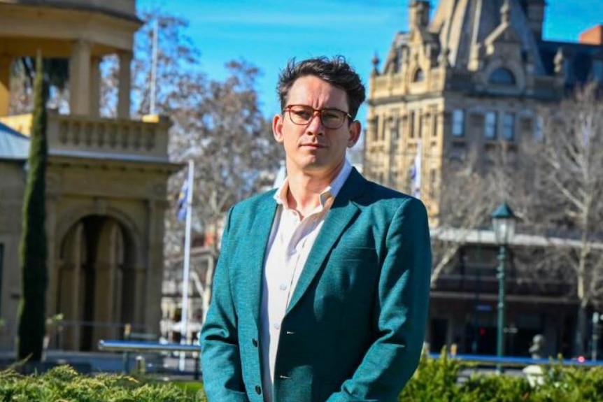 man wearing green jacket and glasses